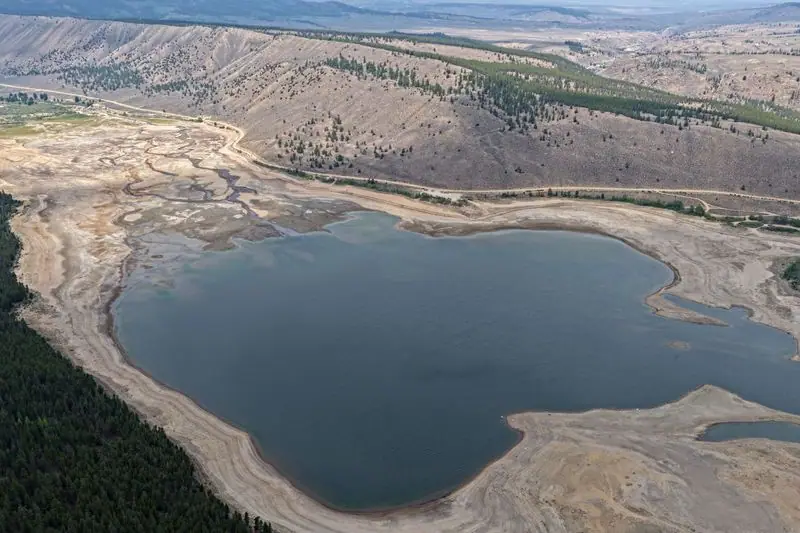 Clear Creek Reservoir at low water, the remaining pool ringed by a wide band of pale exposed bed