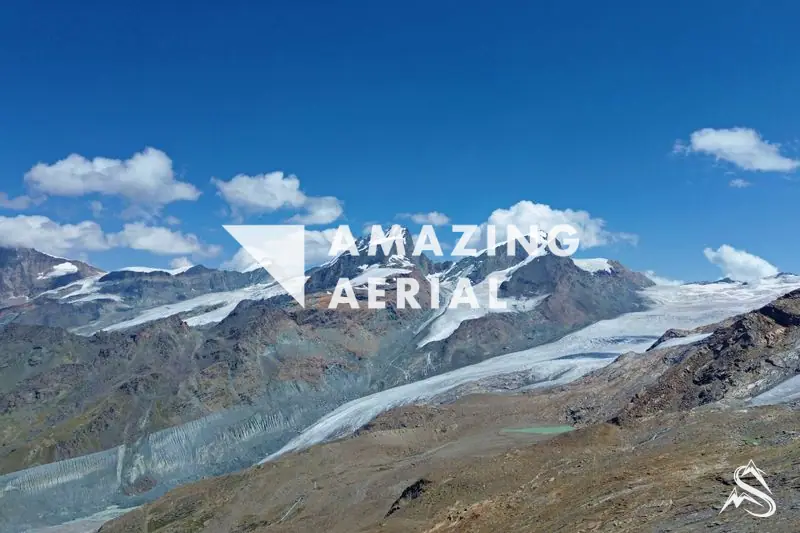 Aerial over a broad alpine glacier and snow-capped peaks in the Zermatt high country