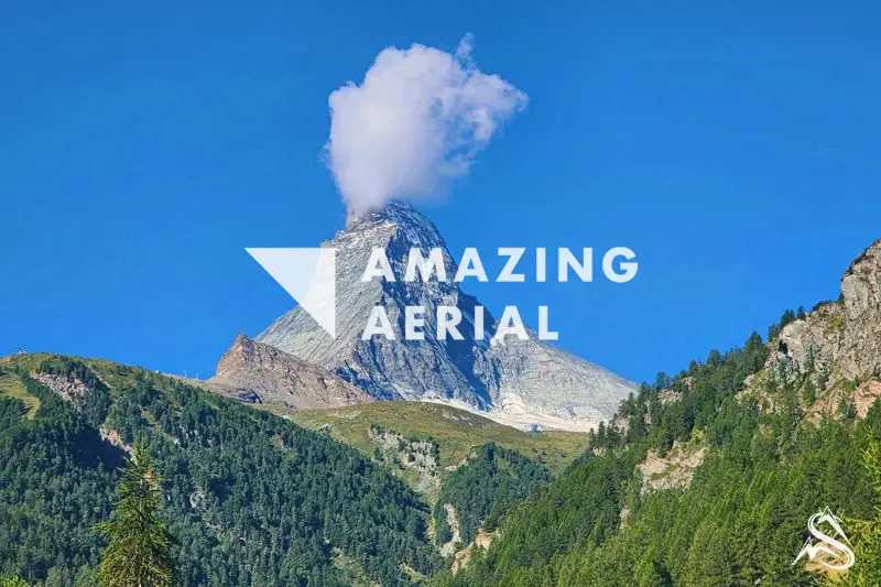 The pyramid of the Matterhorn from a green hillside above Zermatt under a clear sky