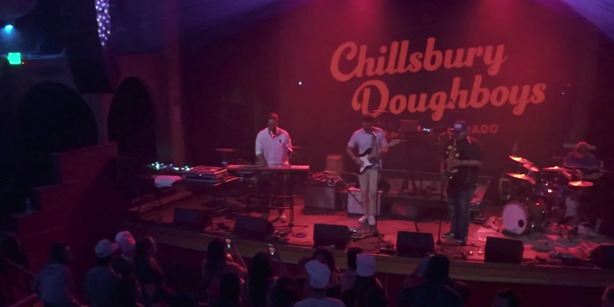 The Chillsbury Doughboys performing at the 2024 Boogie Lights show, viewed from the balcony over the crowd, the act's name lit up on the stage backdrop