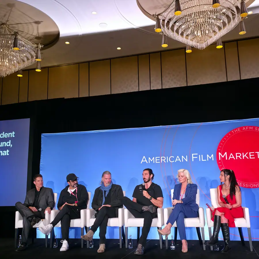 Six panelists seated across the AFM Sessions stage before the American Film Market backdrop.