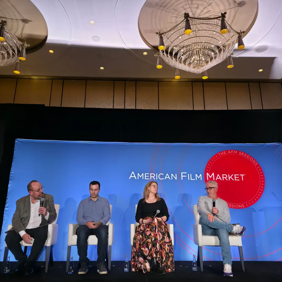 Four panelists seated on the AFM Sessions stage, the moderator on the left mid-question.