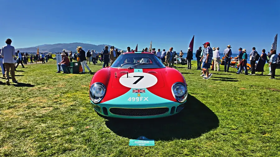 Head-on view of a red Ferrari 250 LM, race number 7, with a UK registration plate reading "499FX," a dense crowd behind