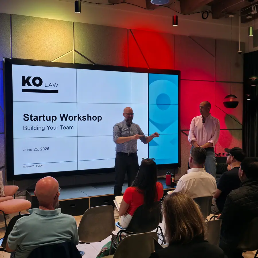 A KO Law startup workshop in session, the room facing the branded screen.