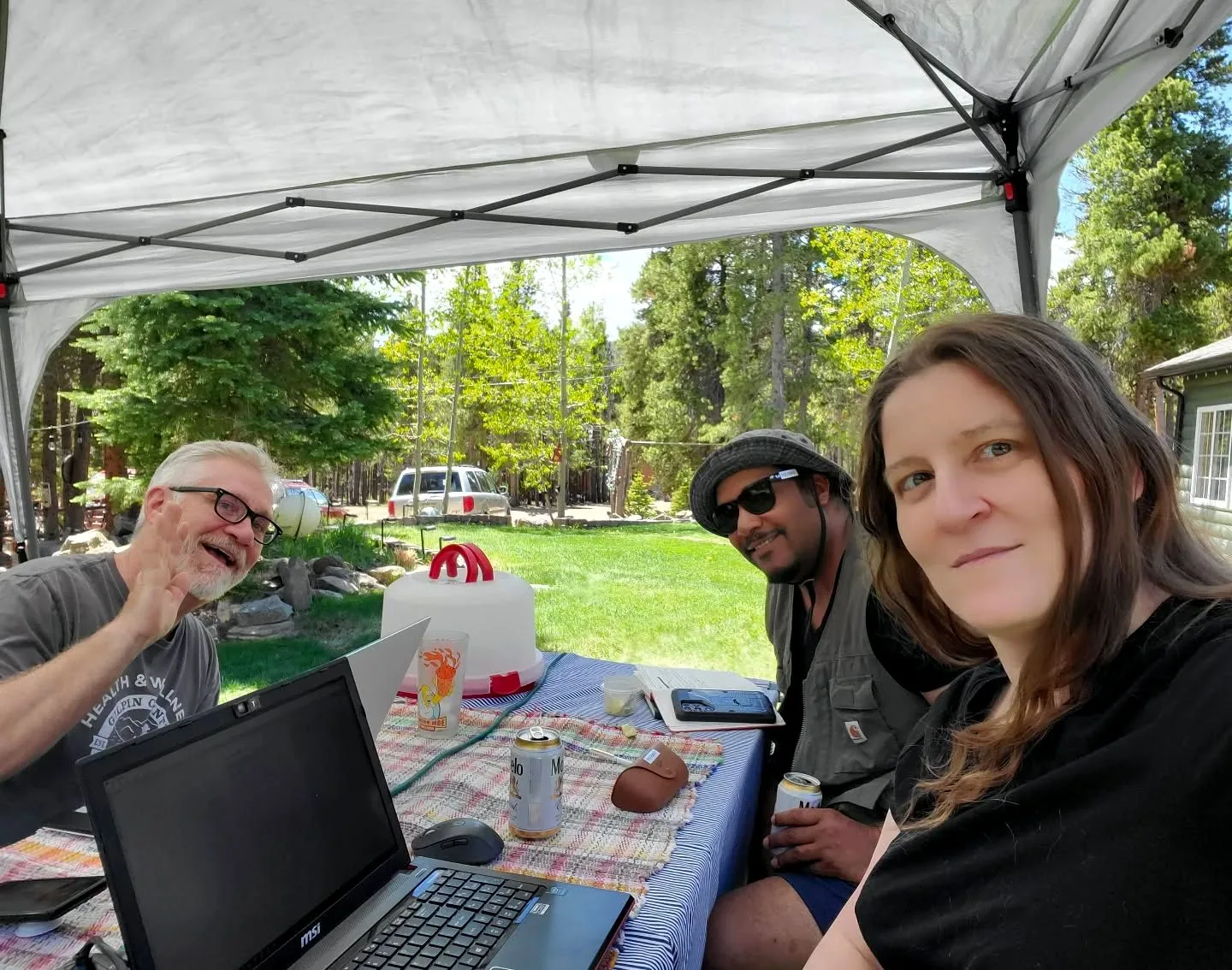 Members outdoors under a canopy at a MEME retreat.