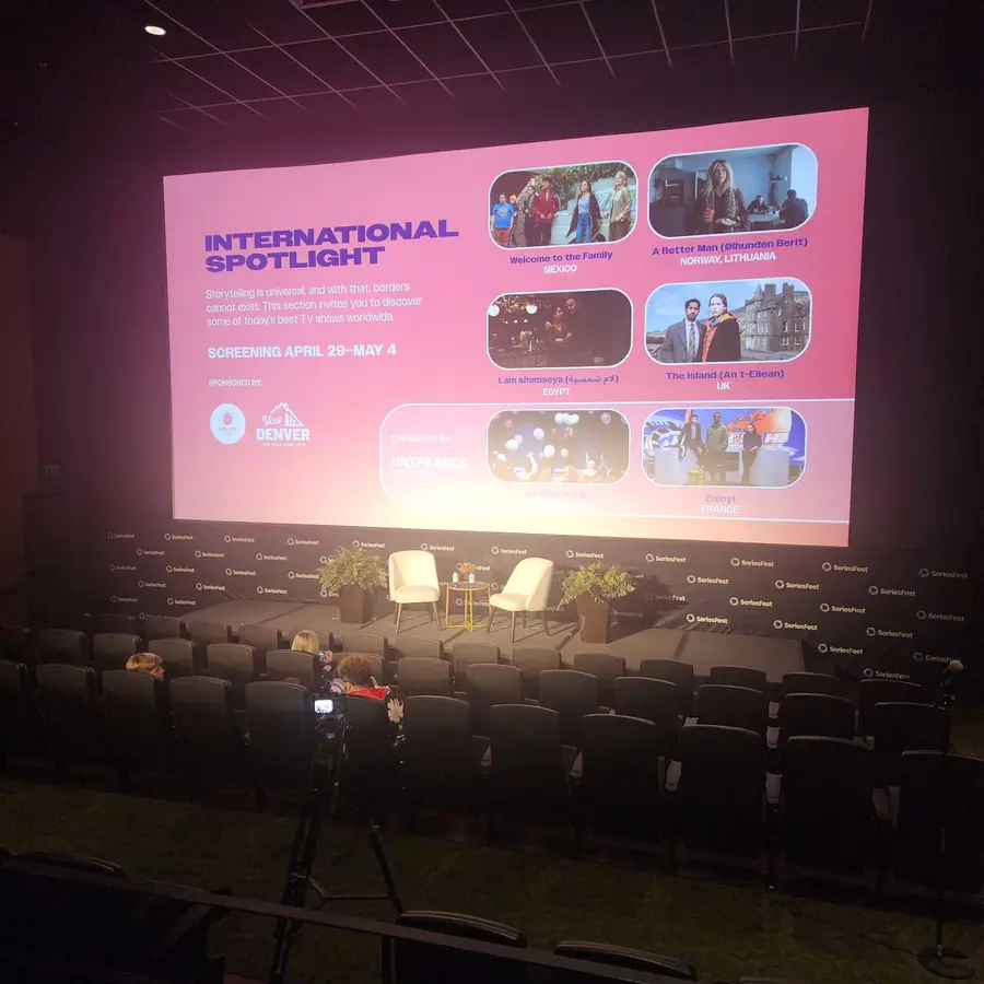 The International Spotlight slate on the big screen — a grid of six series stills — with two empty chairs staged for the post-screening conversation.