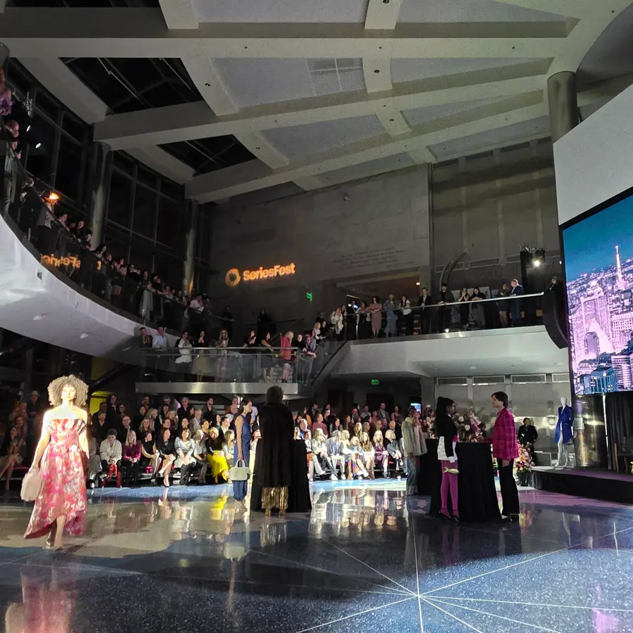 The Cable Center's atrium, a model on the runway, tiered seating rising on both sides.