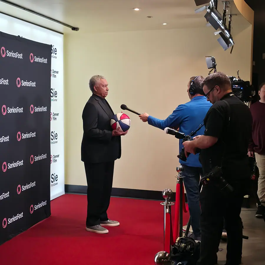 An ABA-jerseyed guest being interviewed on the red carpet, the SeriesFest and Sie FilmCenter backdrop behind.