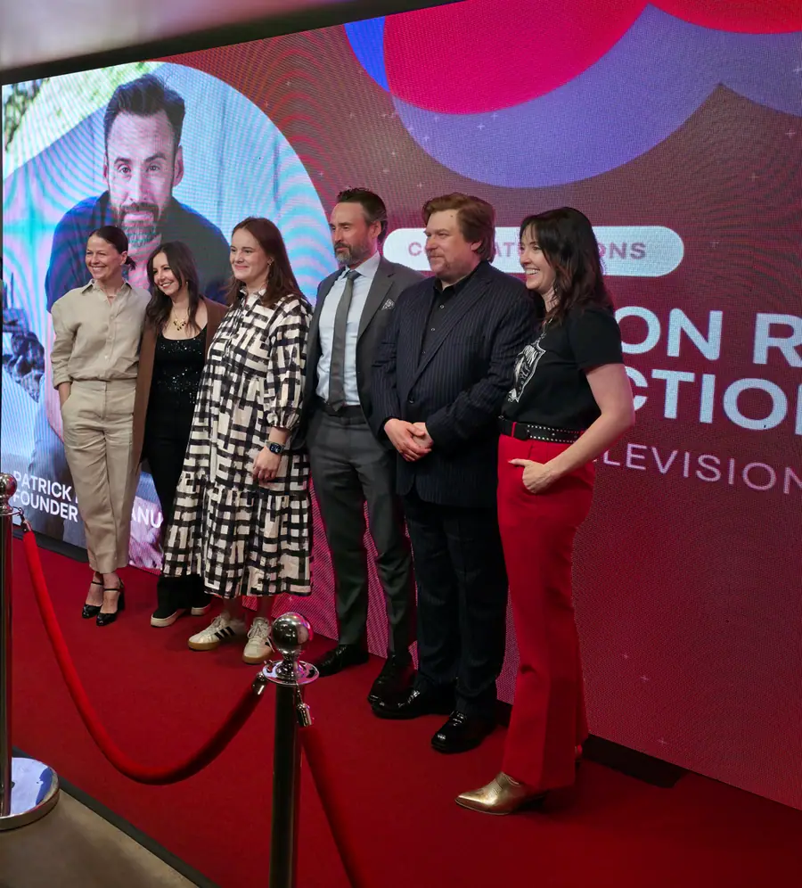 Six people posing on the SeriesFest red carpet in front of a step-and-repeat