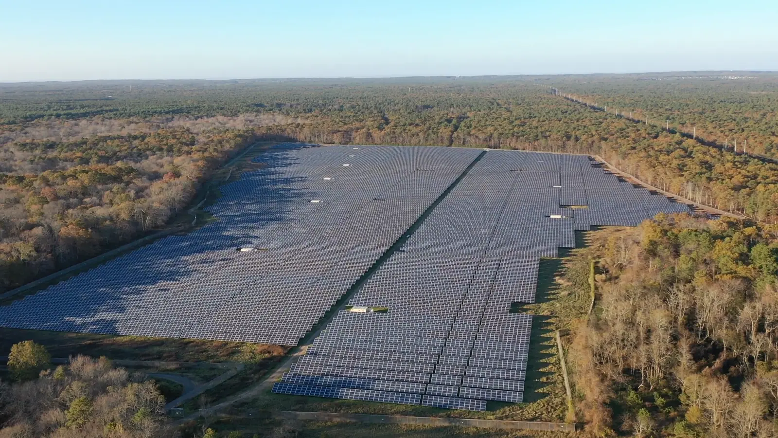 Aerial of a large solar array in a green landscape, from the Hero X Solar film.