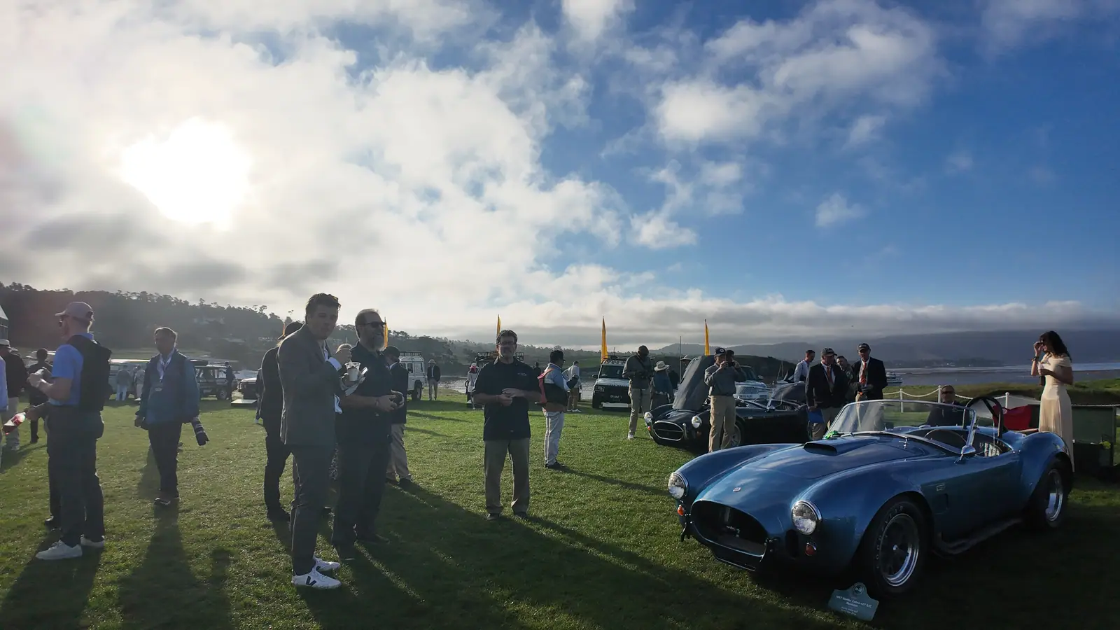 The Cobra on the lawn under a dramatic morning sky with attendees nearby